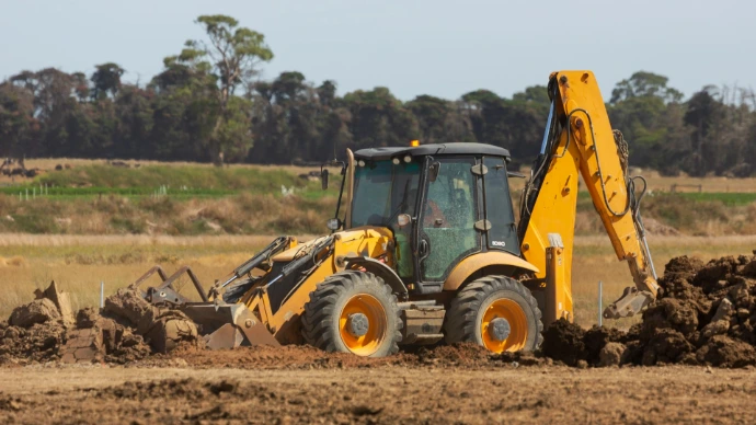a bulldozer digging dirt in a field