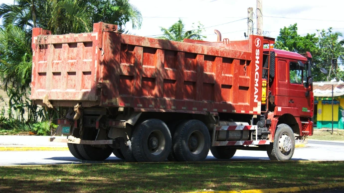 Red dump truck parked on a road.
